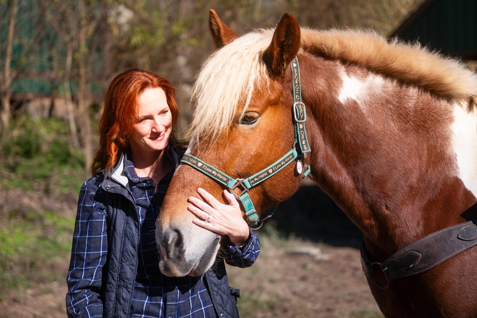 Woman stands with horse as in Georgetown, Kentucky, getting ready to horseback ride through the Kentucky backwoods.